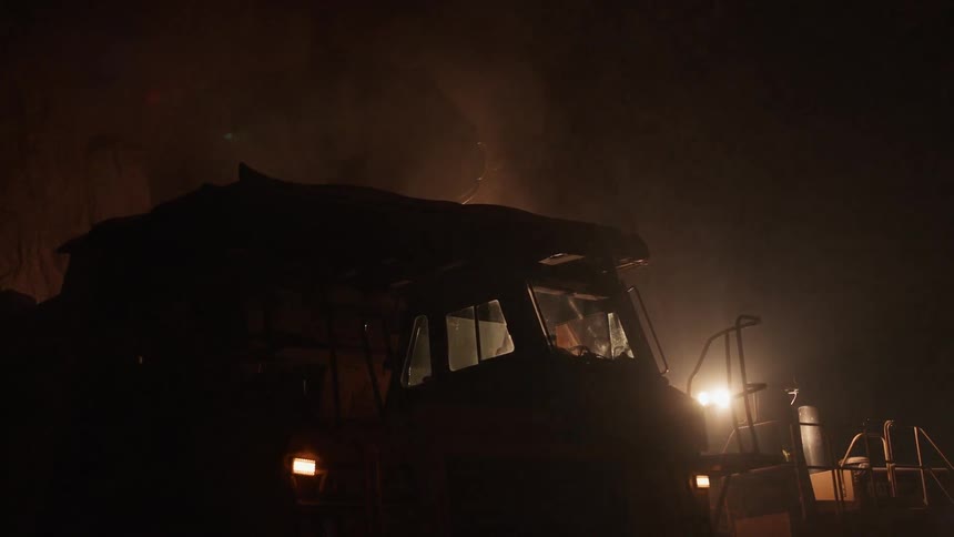 A front loader empties its bucket into a truck