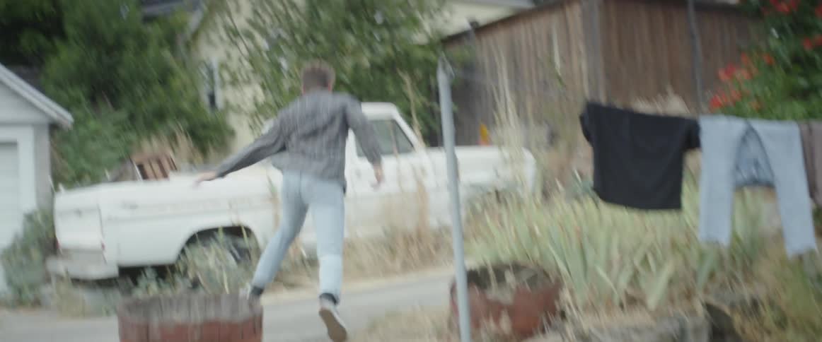 A man runs up the steps and passed a parked pickup