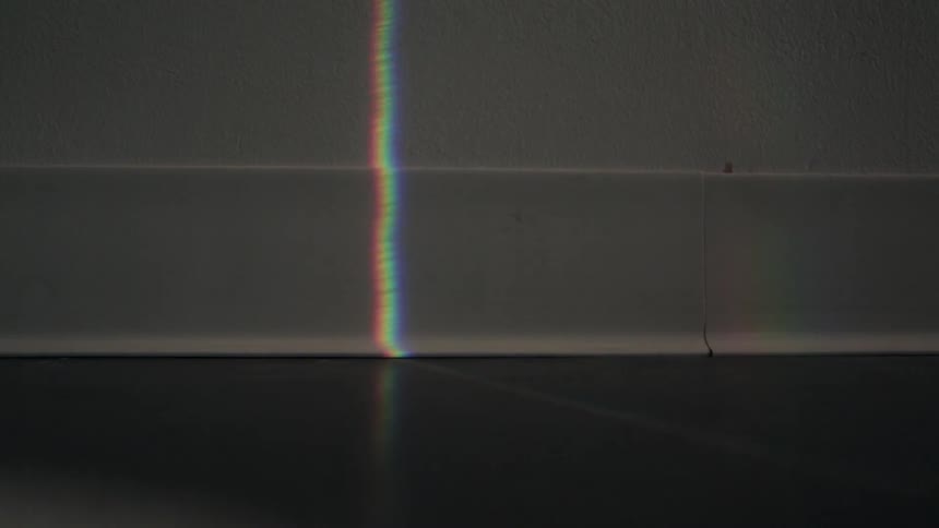Three bands of light shine on a wall and move together and split apart