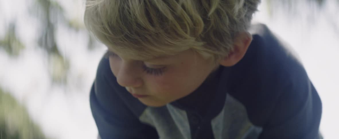 Child looks down towards the ground
