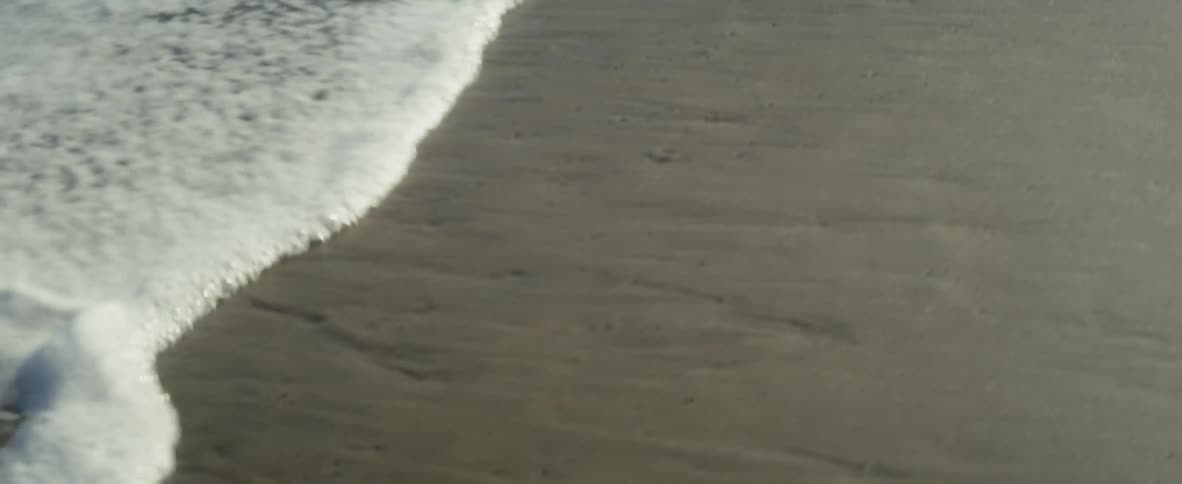 Ocean waves flowing up onto sand beach