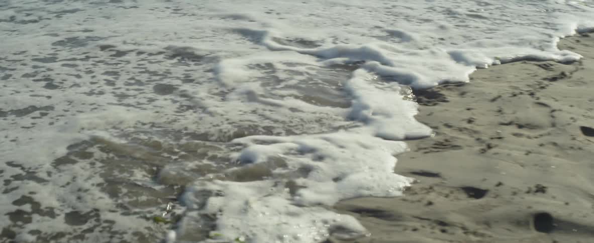Ocean water flowing up onto sandy beach