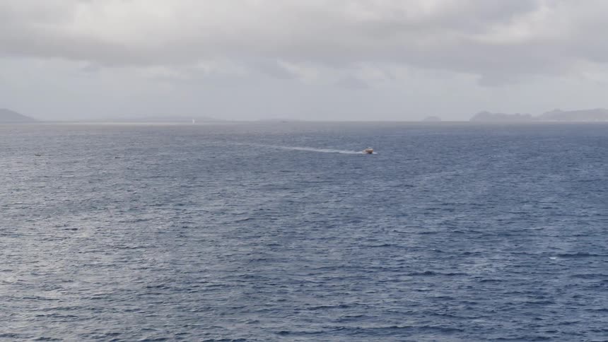 Boat floats on the open water on a cloudy day