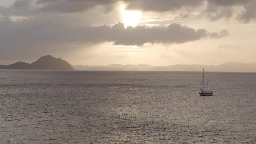 Water flows up to shore and clouds partially cover the sun