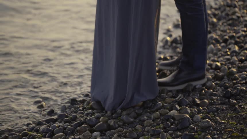 Man and woman standing at the edge of the water
