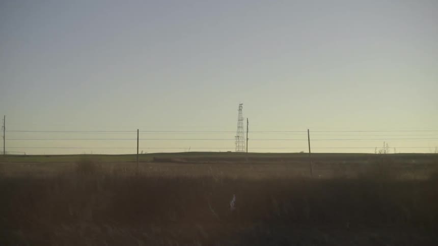 View of a communication tower and power lines in a remote area