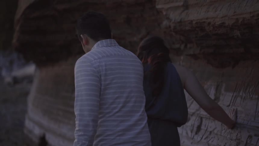 A couple walking by a cliff