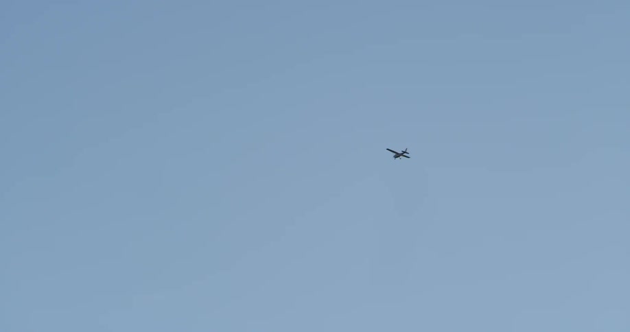 A single engine plane is flying across the sky on a clear day