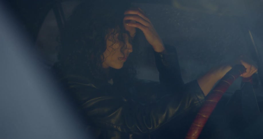 A woman is sitting in the car steering the wheel
