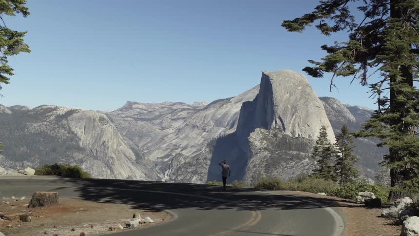 A man walks on a mountain road