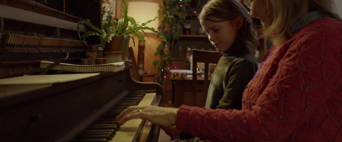A woman and child play a piano