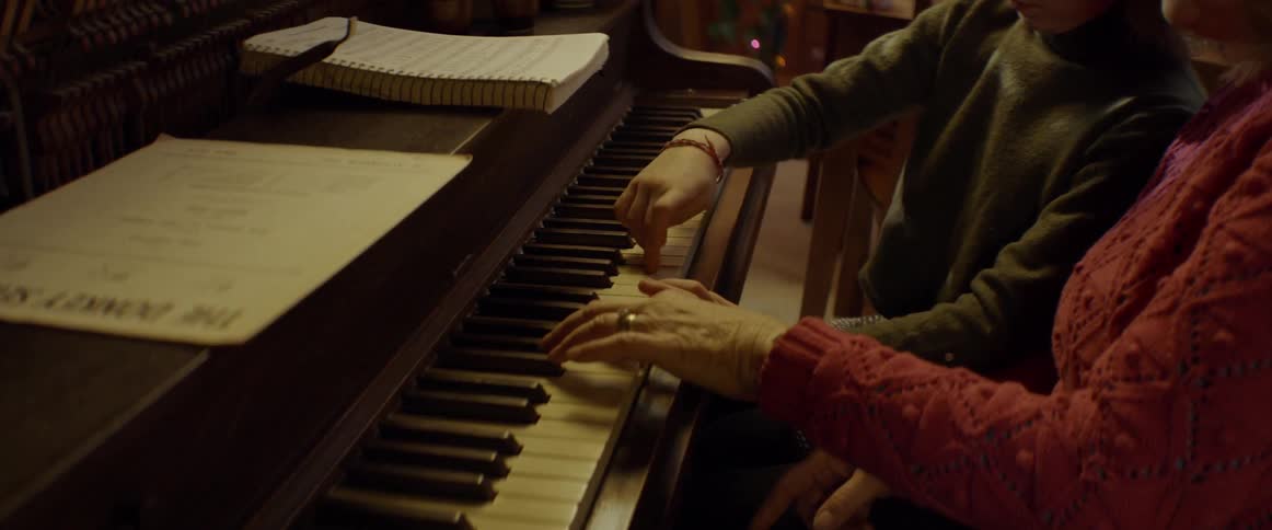 A woman and child play a piano