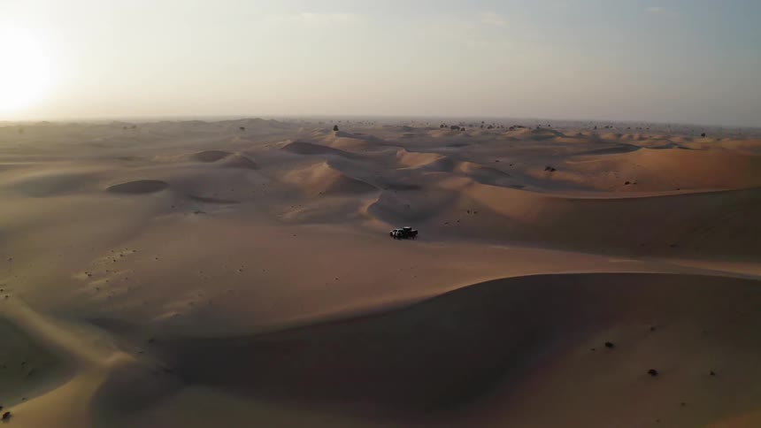 The sun sets over a sandy desert