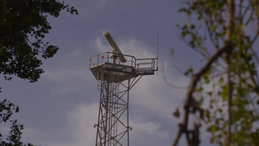 View of a machine on top of a tower on a cloudy day