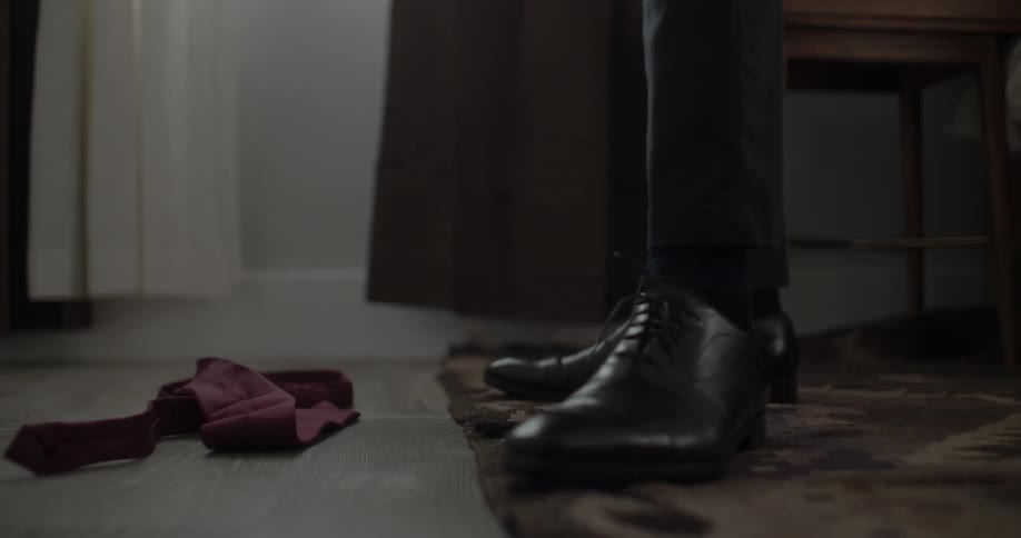 A man drops a tie to the floor
