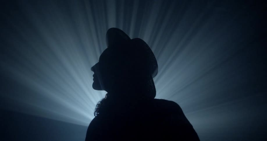 Silhouette of a person standing in beams of light