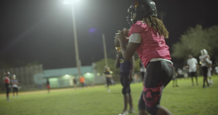Boys play football at night