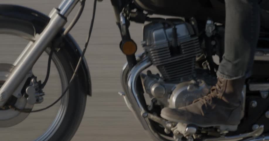 A motorcyclist rides across a dirt field
