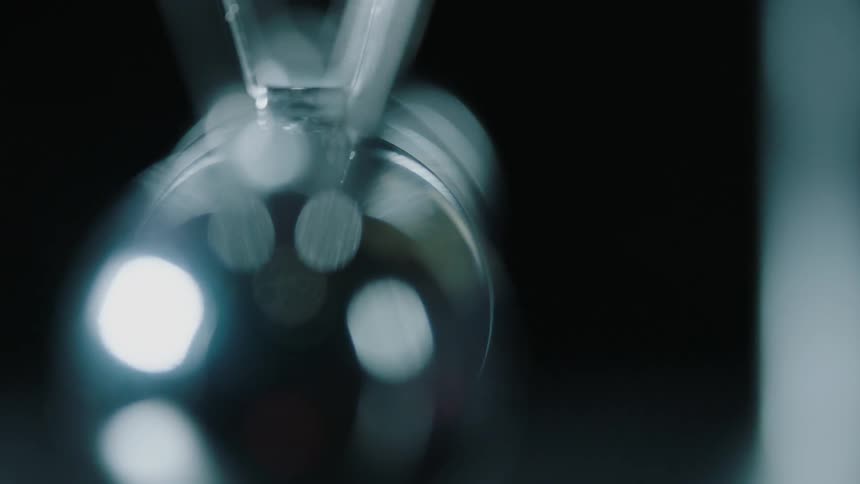 Light reflects off the metal balls of a newton's cradle