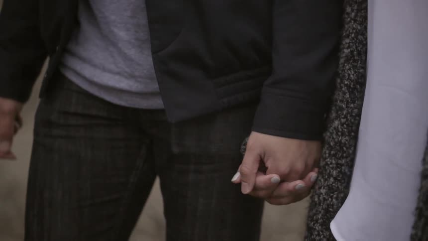 Man and woman hold hands as they walk
