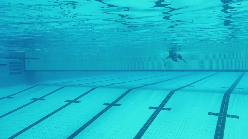 A man swims in a swimming pool