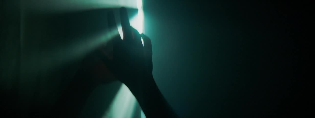 Person's hands waving around in a light beam