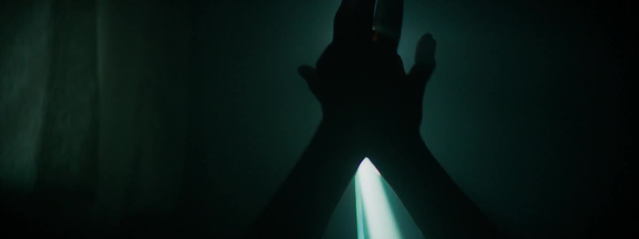 Lights shine behind a pair of hands