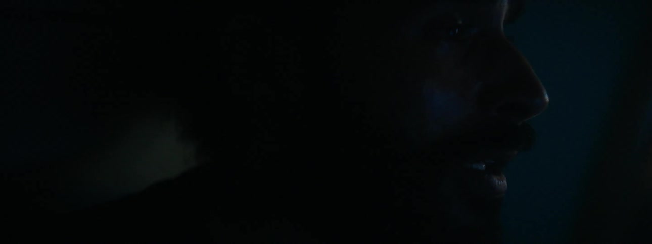 Lights flash on a man in a dark room