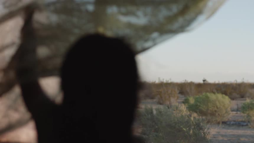 Child pulls open a curtain on a windy day