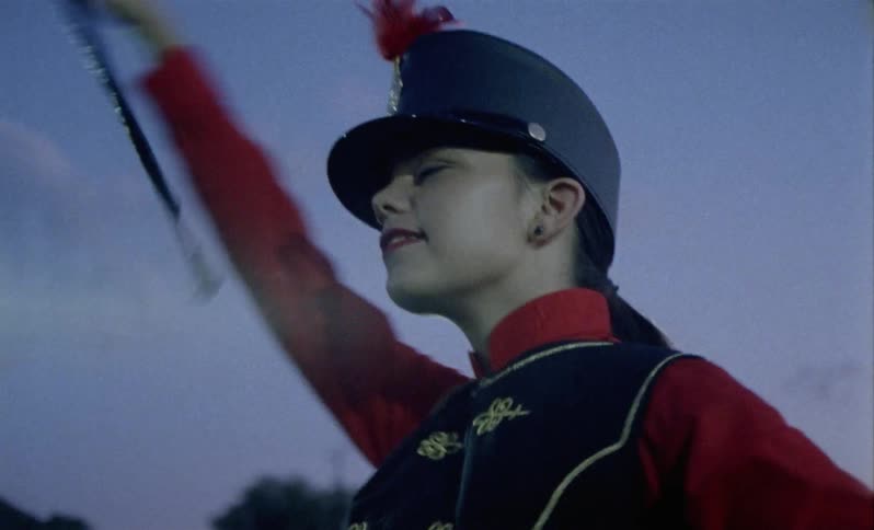 A woman is leading a band on the field
