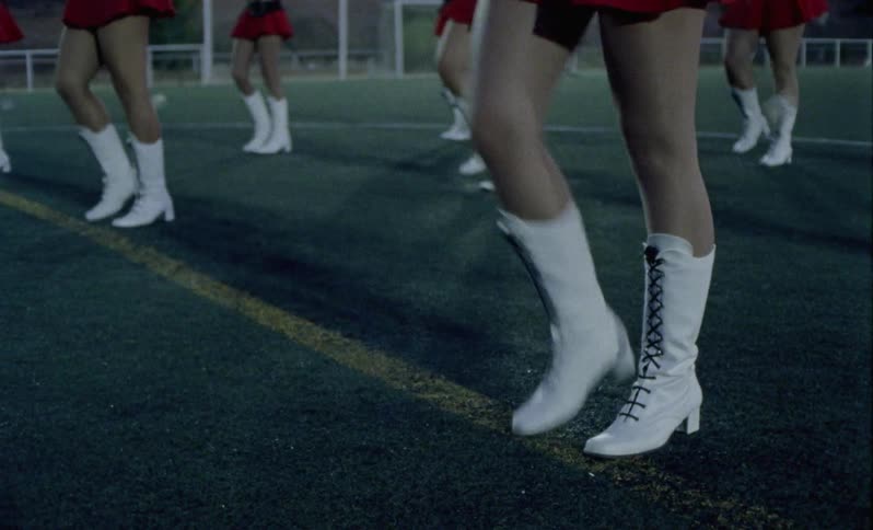 A team of dancers performs on an athletic field
