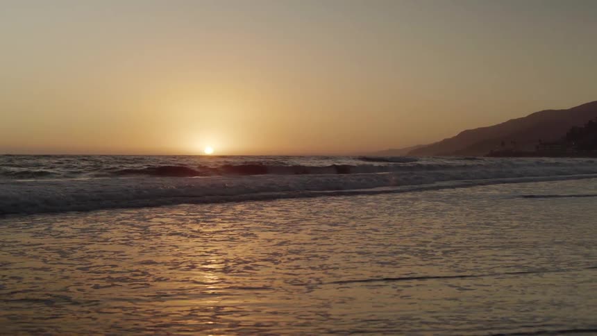 Ocean waves come to shore at sunset