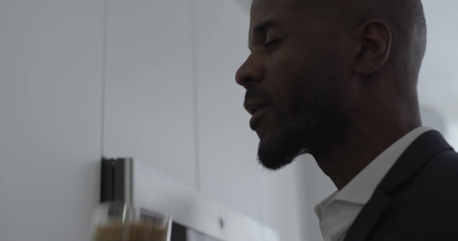 A man sips coffee in a kitchen