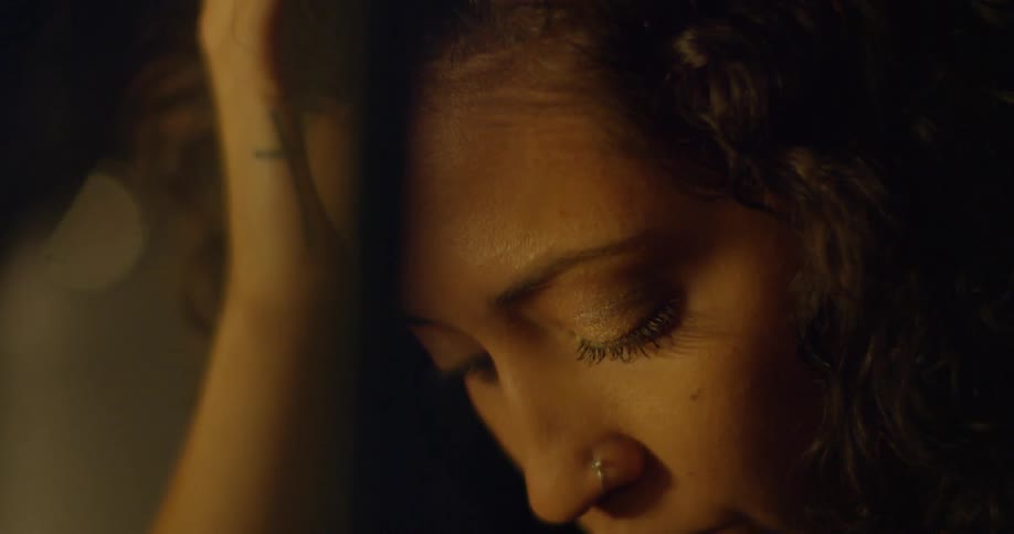 A woman rubs her hand through her hair