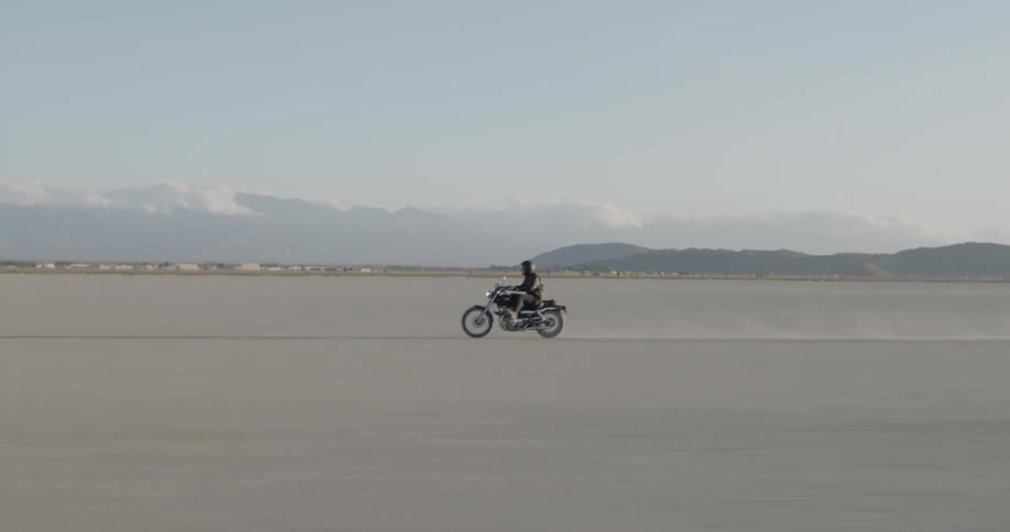 A person stands up as they race on a motorcycle