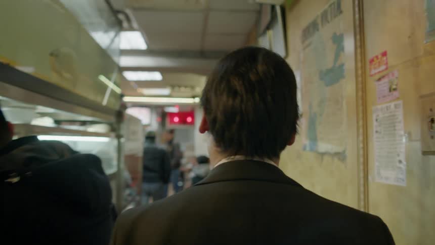 A man opens the door and walks into a diner