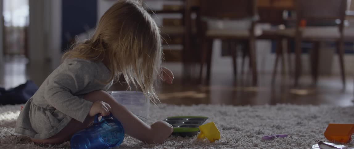 Young girl plays on a rug