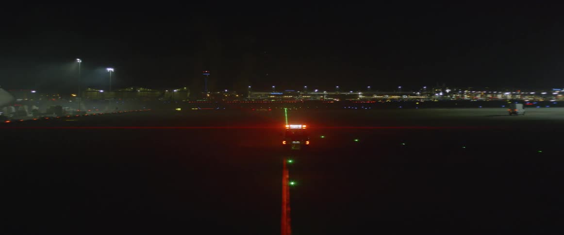 A vehicle with flashing lights drives at an airport