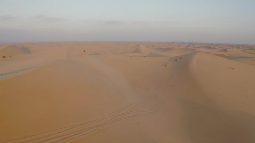 Sand dunes cover a desert landscape