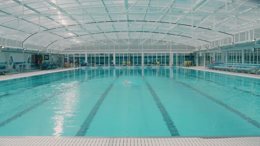 A man swims in an indoor pool