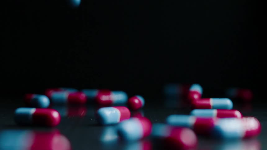 The red and white pills fall on the table