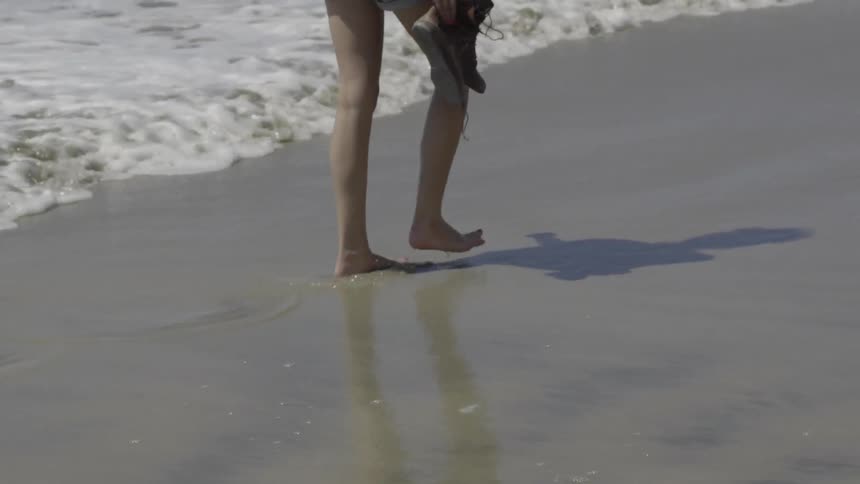 A girl walks down the beach