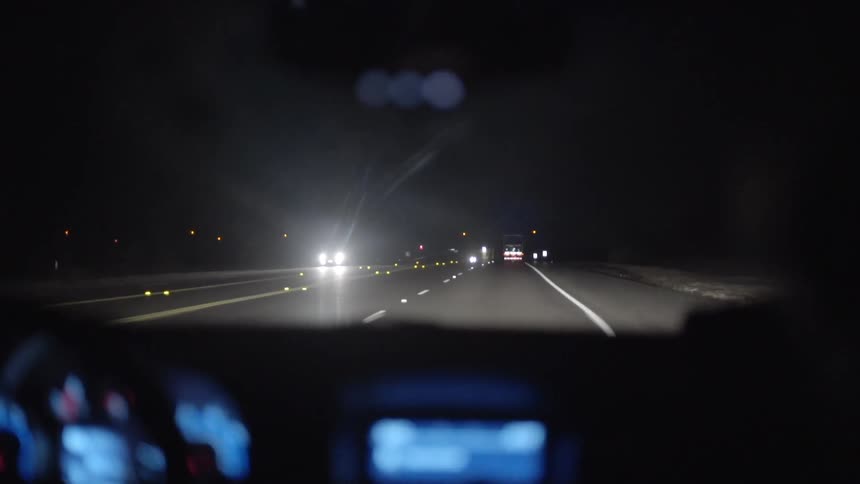 Cars traveling down a road at night