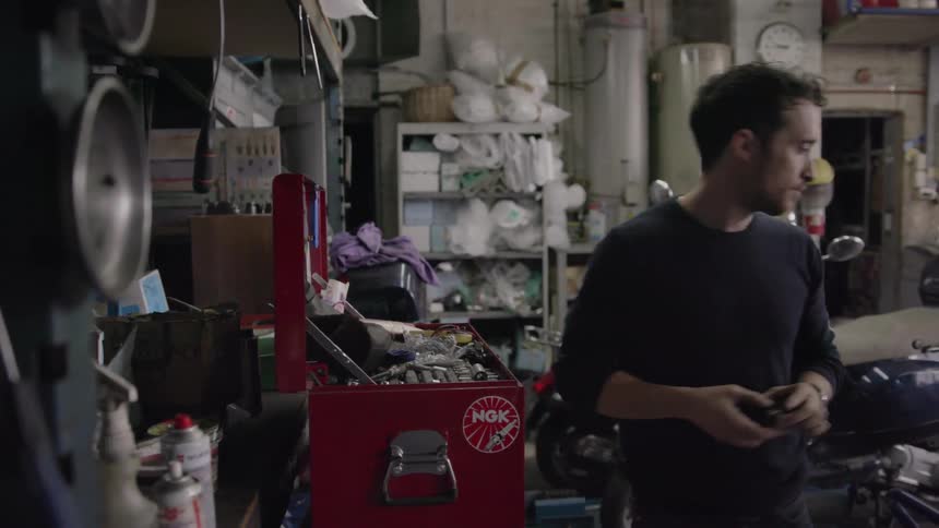 Man looks at a tool and walks away from the toolbox