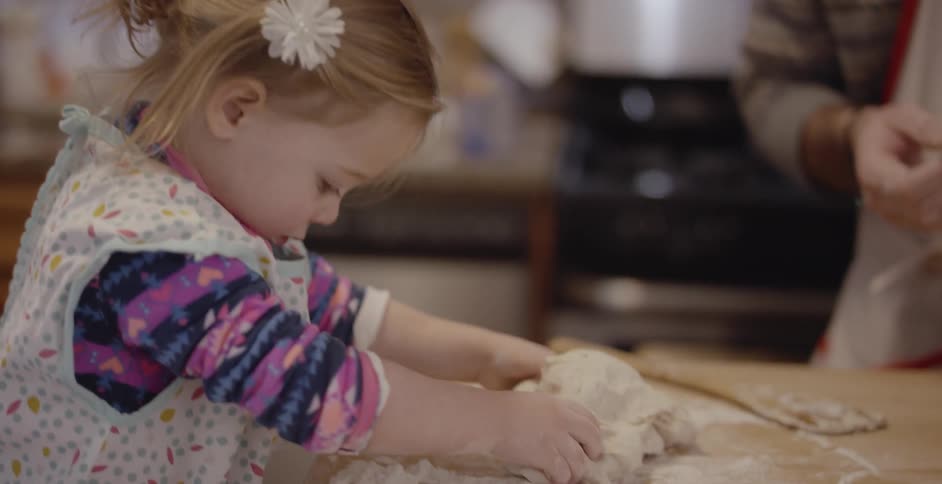 The child helps a person prepare food
