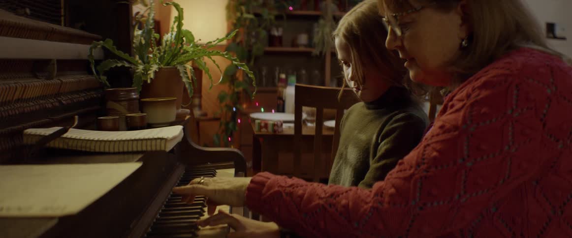 A woman and child play a piano