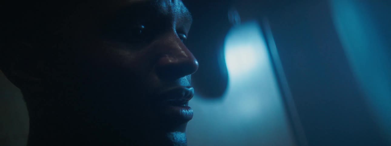A man looks worried while sitting in a dark room