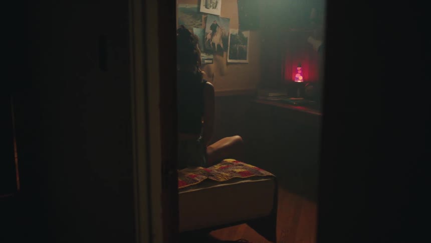 A woman sits in a bedroom