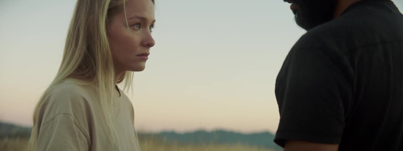 A woman blinks slowly while staring at a man