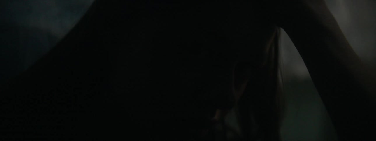 A girl sits in a dark room